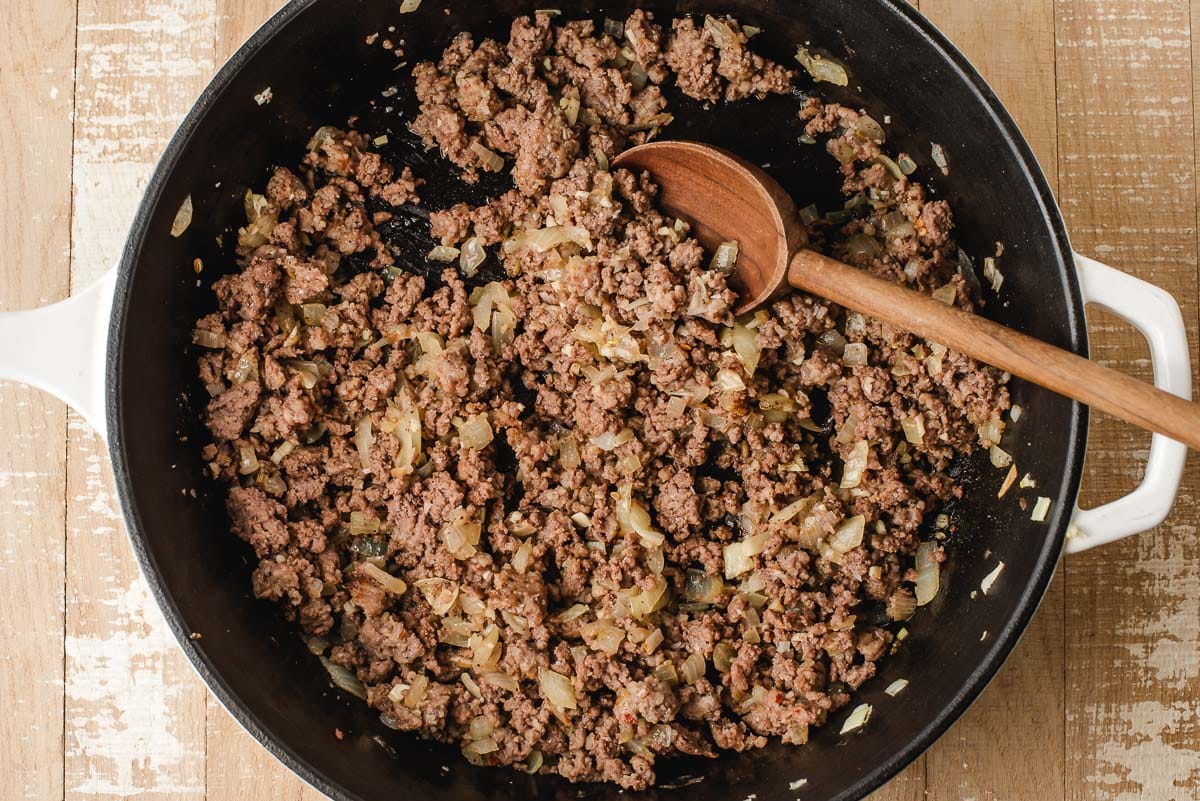 Sauteed onions and ground beef in a chicken fryer.