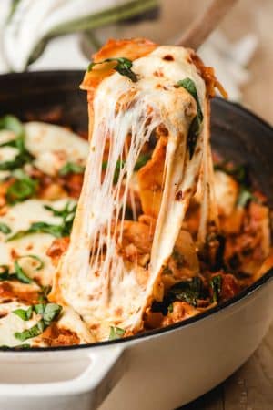 Scoop of one pot lasagna with lots of gooey, melty mozzarella cheese strings hanging down.