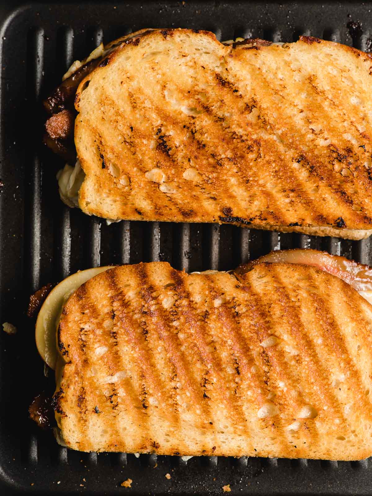 Two grilled cheeses shown on a grill pan.