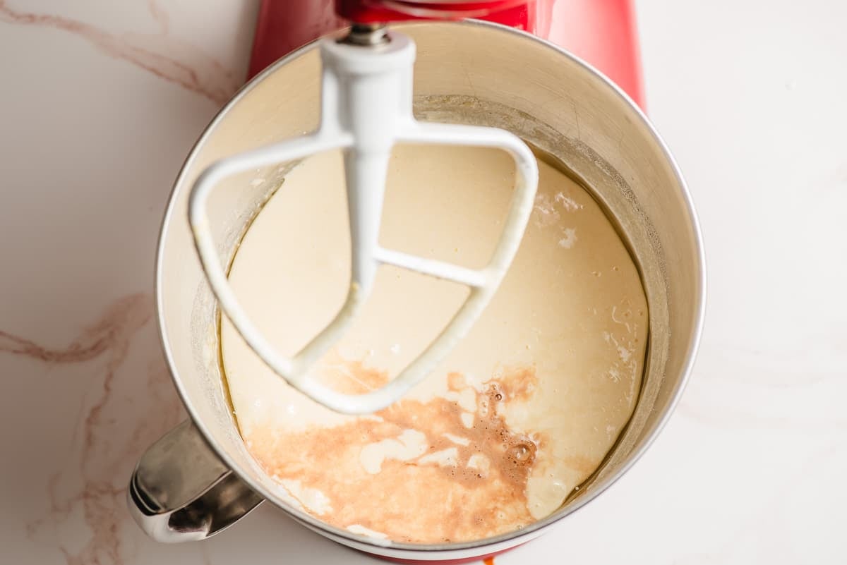 Vanilla extract and buttermilk being stirred into a cake batter mix.