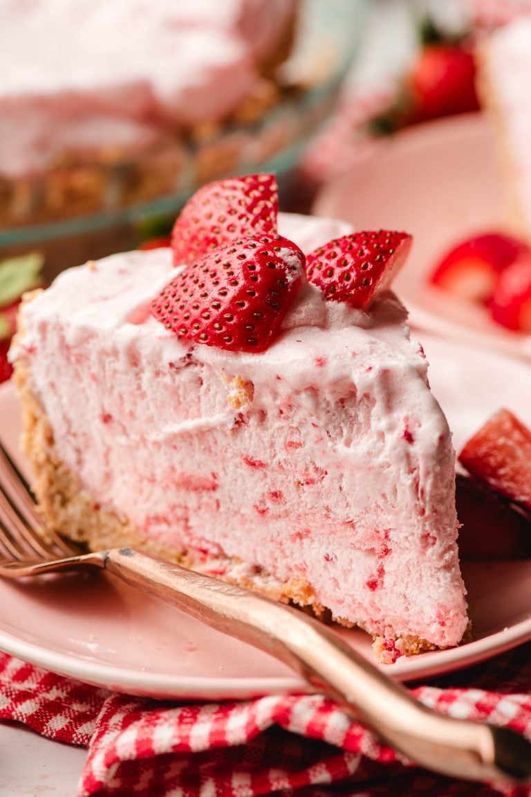 Slice of frozen strawberry pie topped with sliced strawberries.