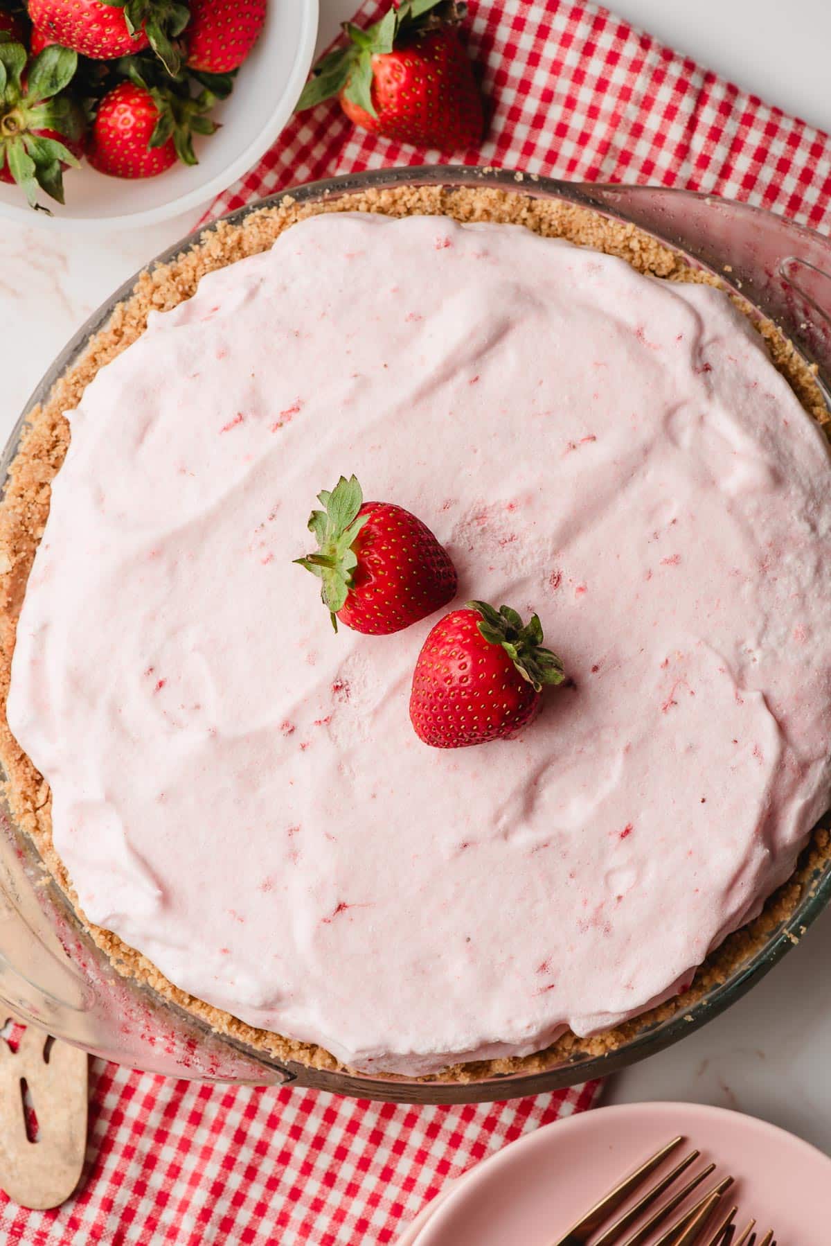 Frozen strawberry pie topped with two strawberries.