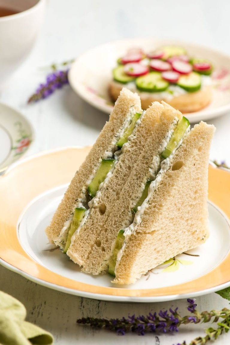 triangle cucumber sandwiches on a yellow rimmed plate