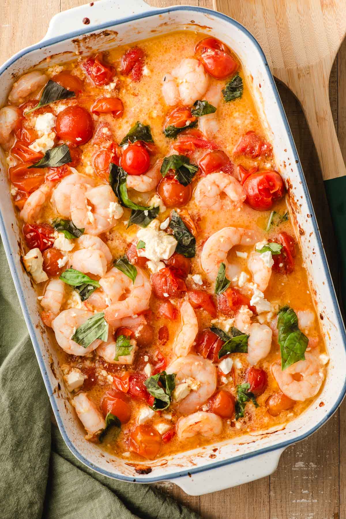 Roasted tomato shrimp bruschetta with feta and lemon in a white baking dish.