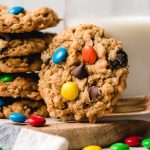 Gluten Free Monster Cookies in a stack with milk.