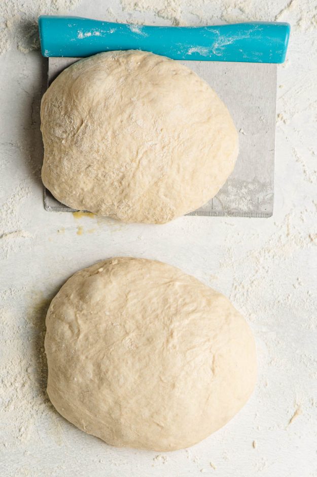two pizza dough balls ready to shape