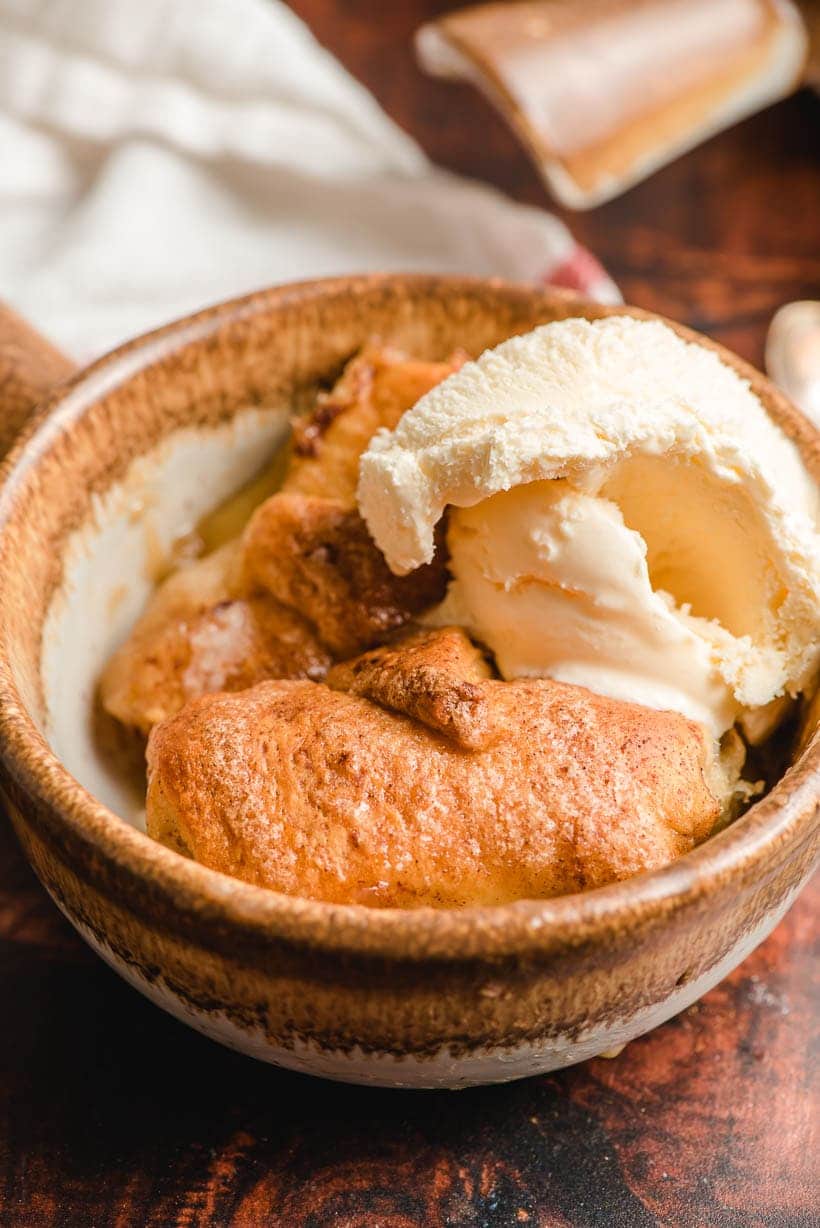 baked crescent roll apple dumpling with scoop of vanilla ice cream