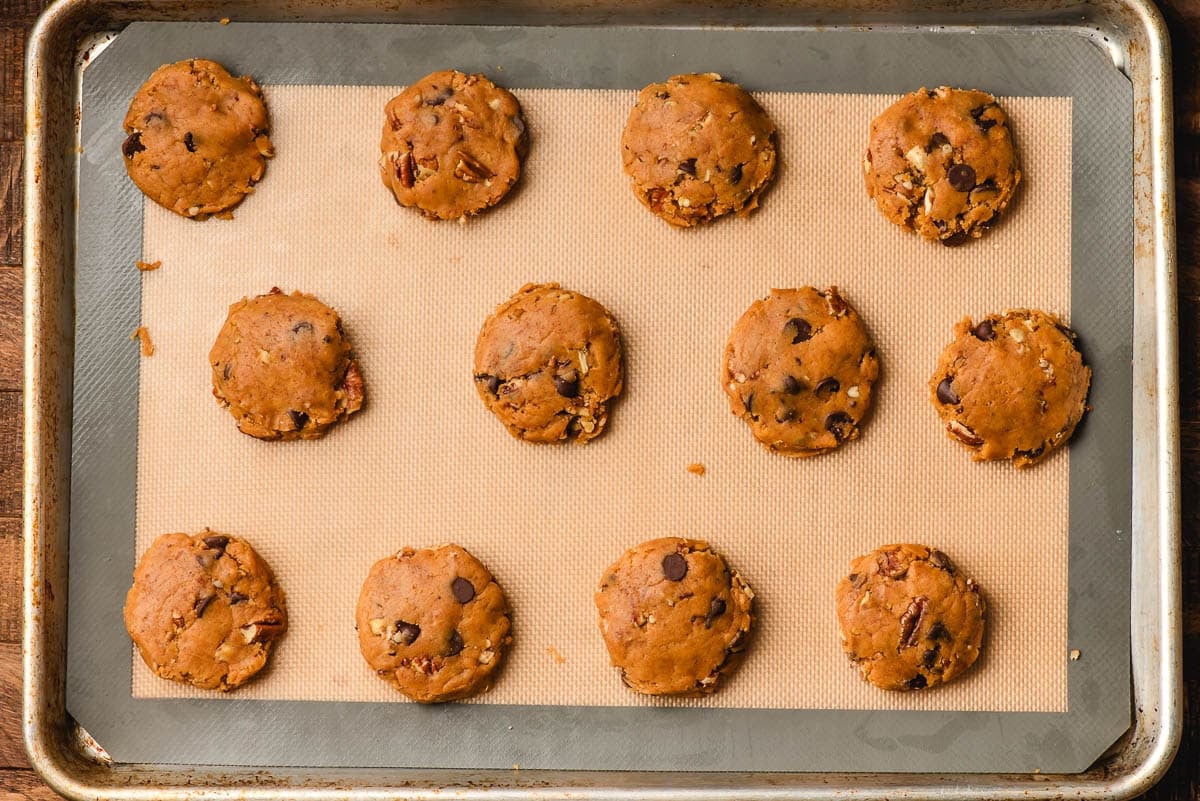 Unbaked pumpkin chocolate chip cookies on a baking sheet.