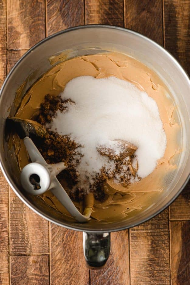 Sugar and brown sugar added to beaten butter and peanut butter in a mixing bowl.