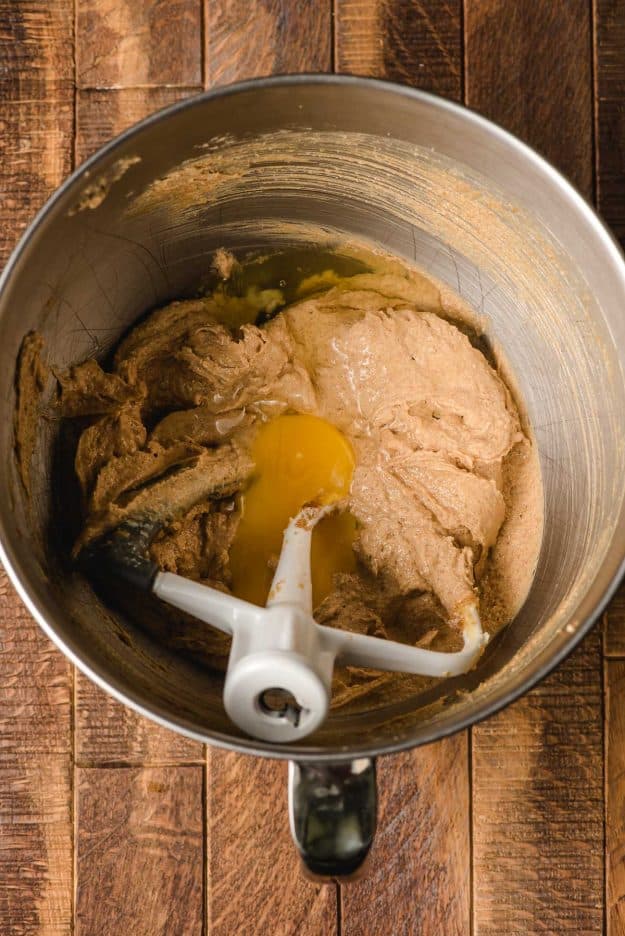 Eggs stirred into a peanut butter mixture in a mixing bowl.