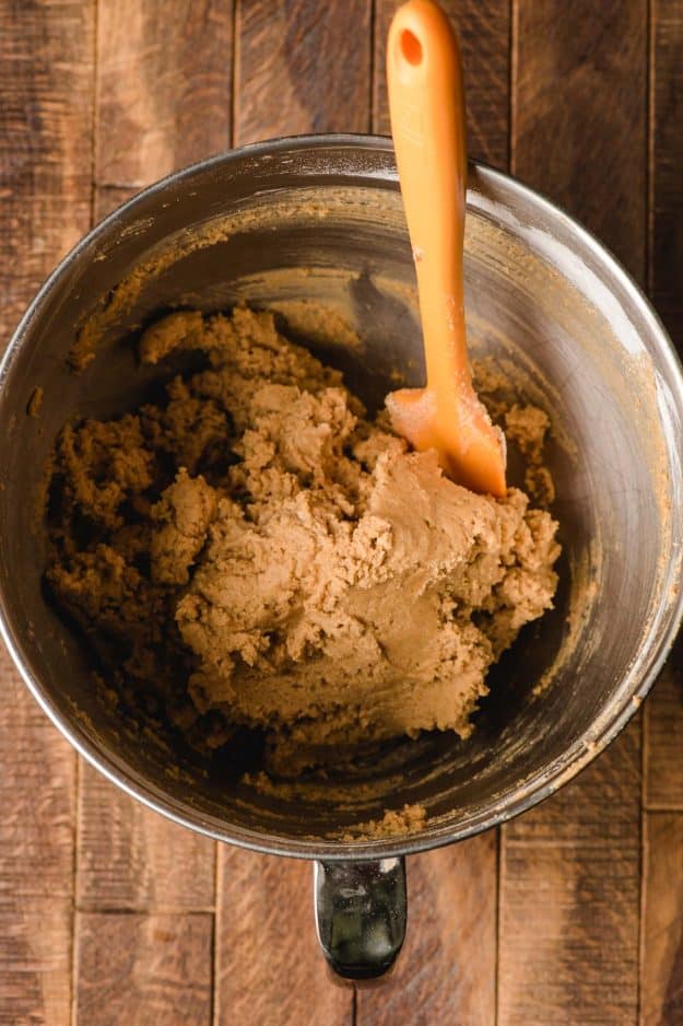 Peanut butter cookie dough in a stainless steel mixing bowl.