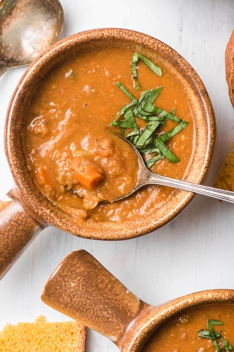 spoon dipping into a bowl of vegan lentil soup