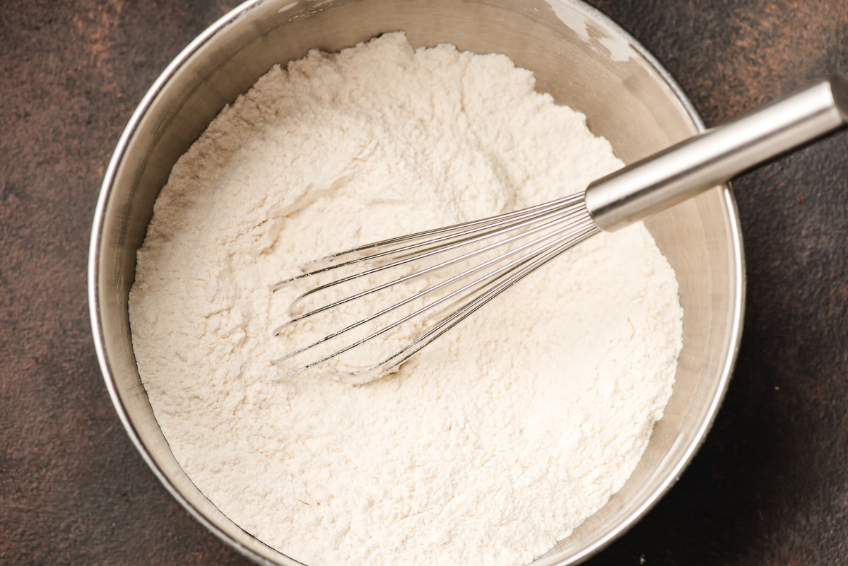 Flour, baking soda, and salt whisked together in a mixing bowl.