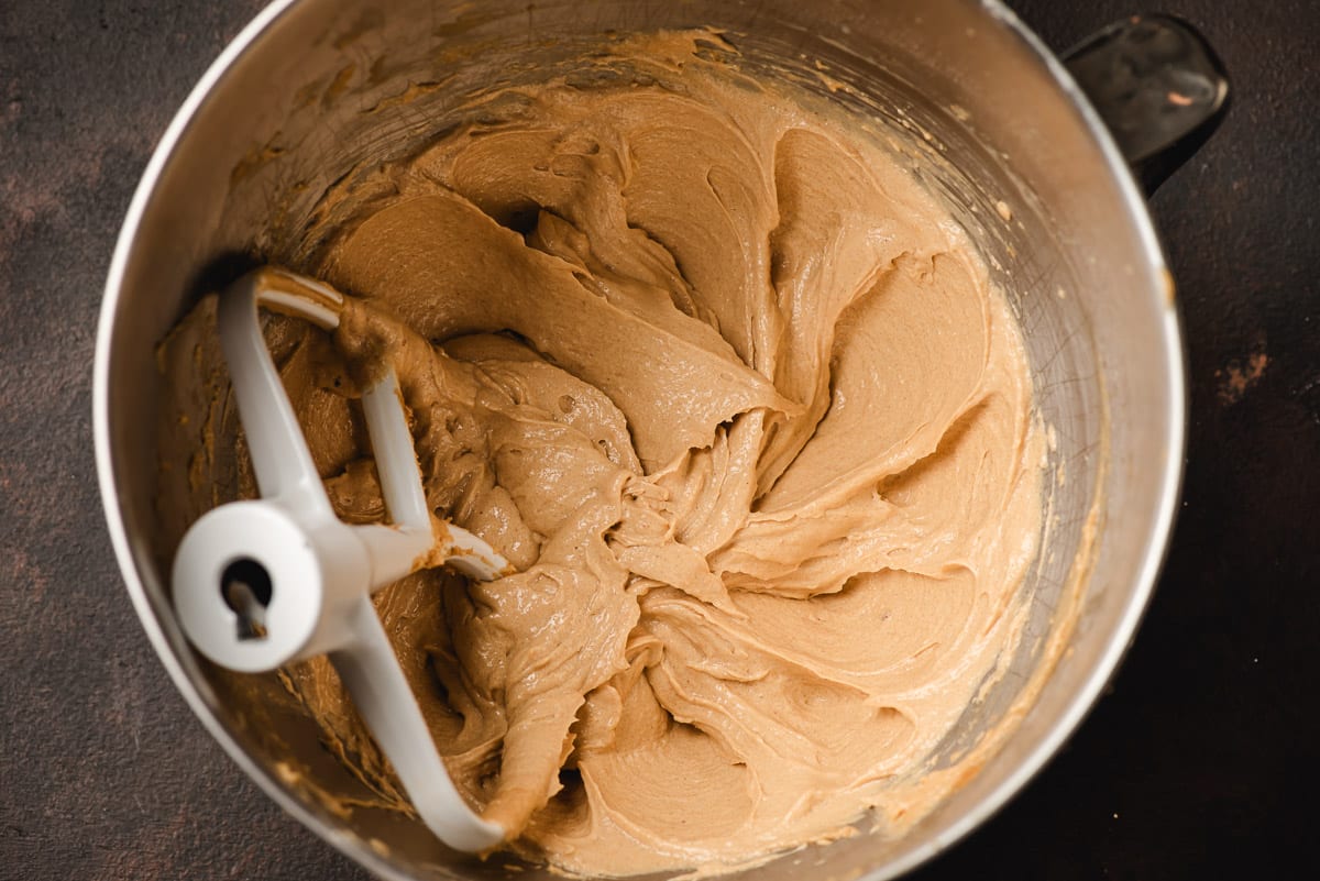 Peanut butter, butter, eggs, and sugars whipped in the bowl of an electric mixer.