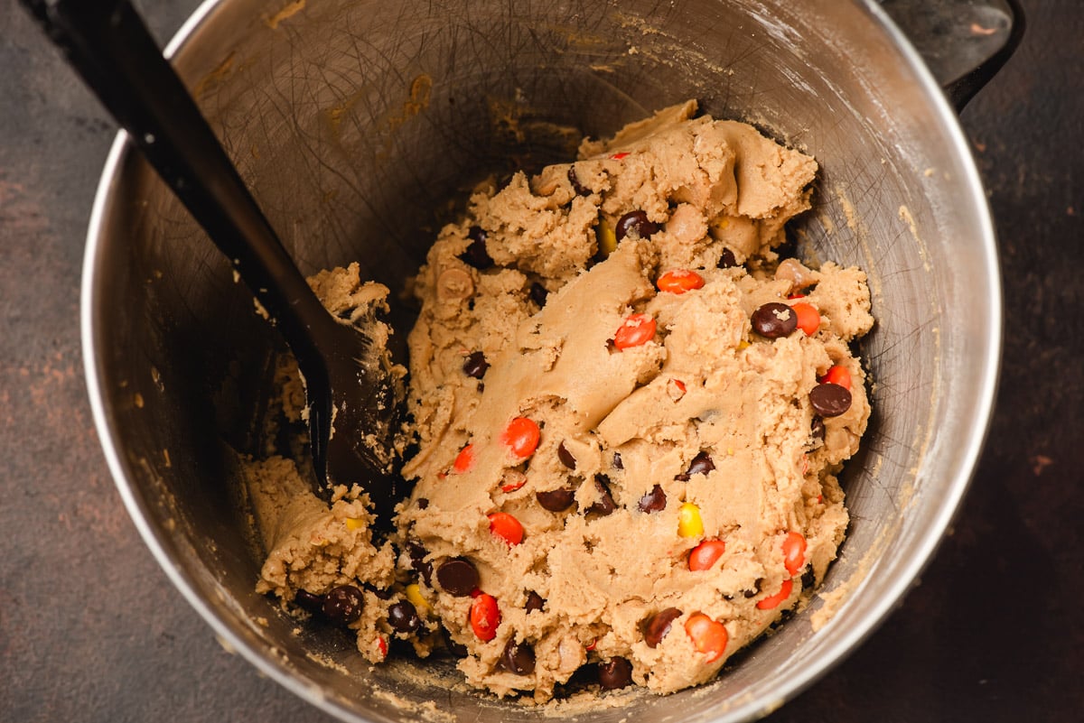 Reese's pieces, chocolate chips, and peanut butter chips stirred into peanut butter cookie dough.