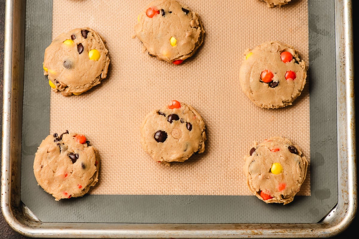 Unbaked balls of peanut butter cookie dough on a baking sheete.
