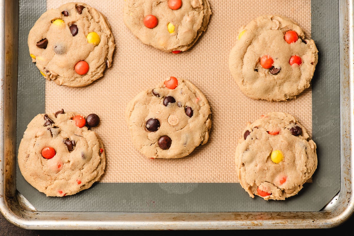 Freshly baked Reese's Pieces Cookies on a baking sheet.