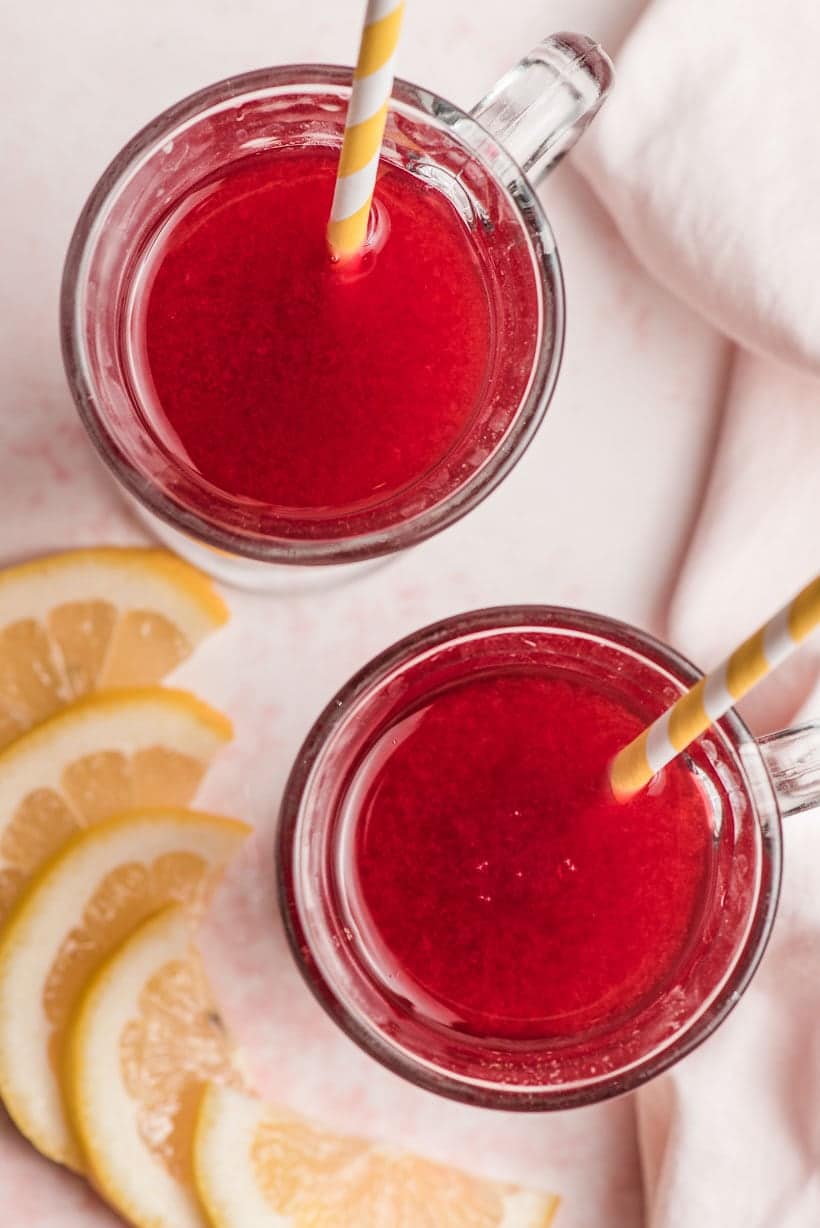 two glasses of pink raspberry cordial with lemon slices