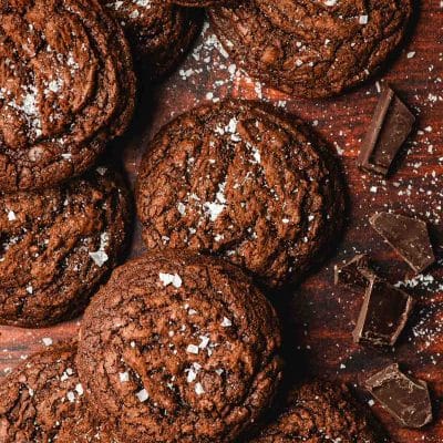 Lots of salted brownie cookies arranged on a dark background.