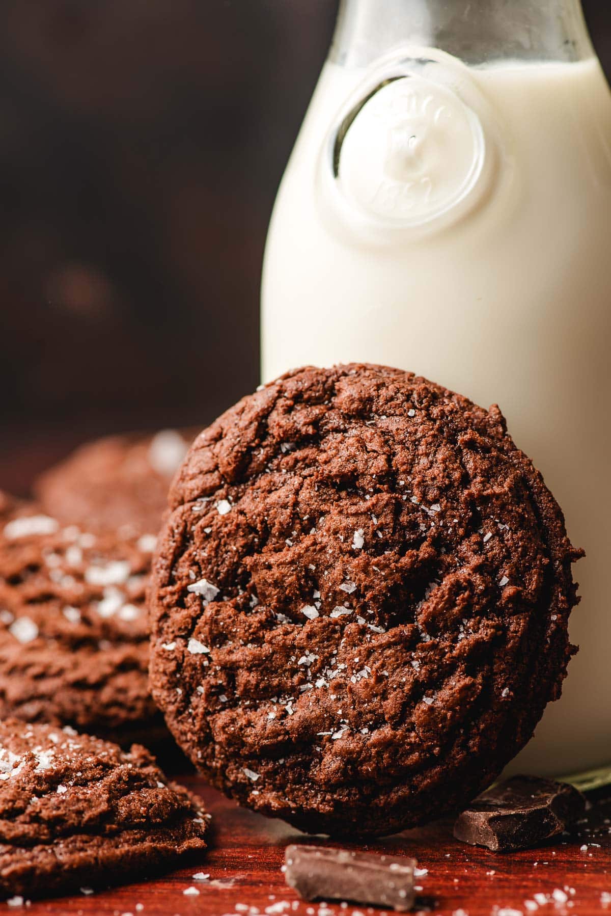 Chocolate brownie cookie propped on a glass of milk.