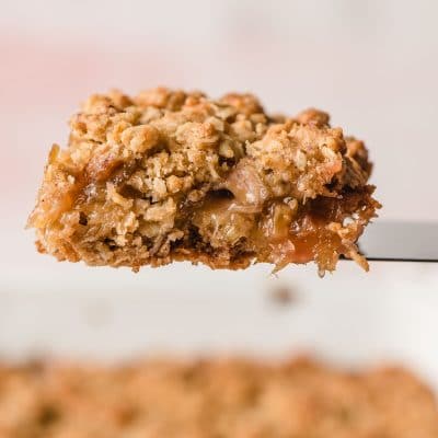 Slice of oatmeal rhubarb bar on a spatula.