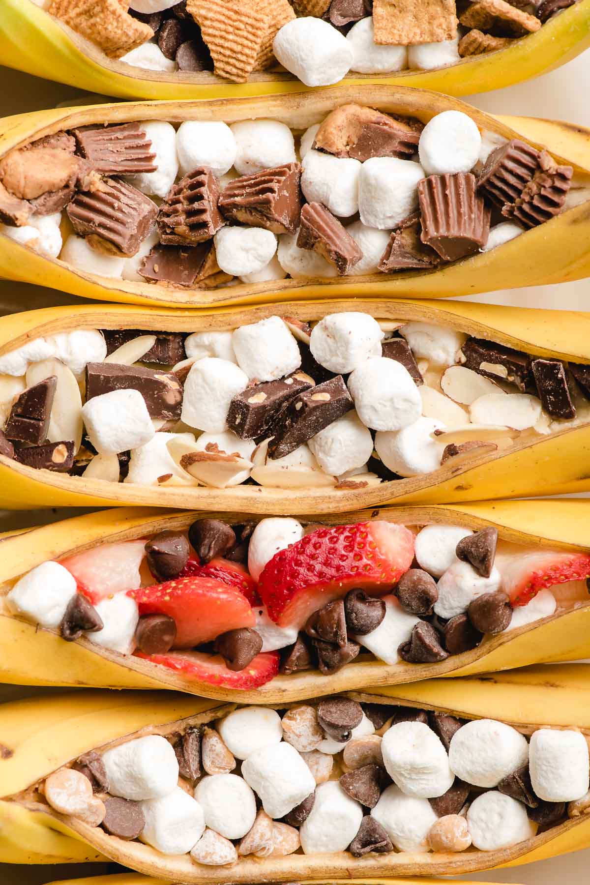 Bananas sliced open and stuffed with marshmallows, chocolate chips, reeses, and strawberries.