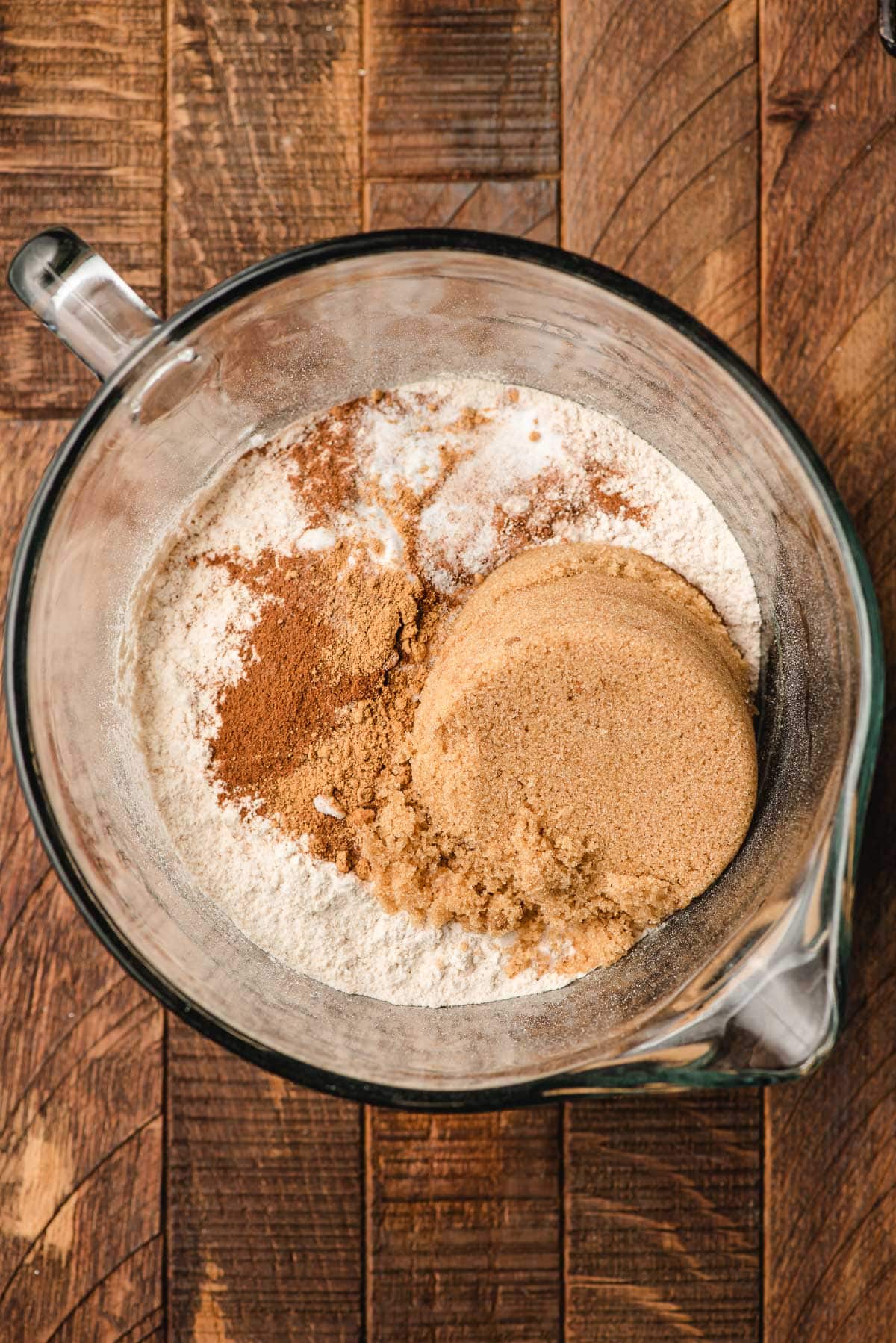 Flour, spices, salt, baking soda, and sugar in a large glass mixing bowl.