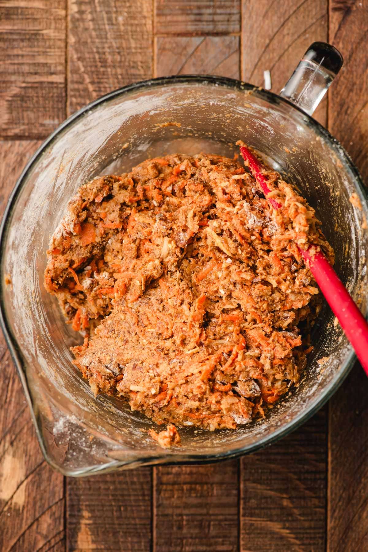 Flour, spices, and sugar mixed with shredded carrots, apples, coconut, nuts, and flax seed.