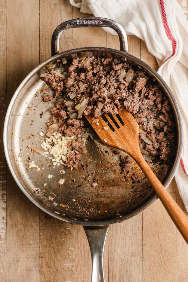 Sauteed ground beef and garlic in a stainless steel pan.