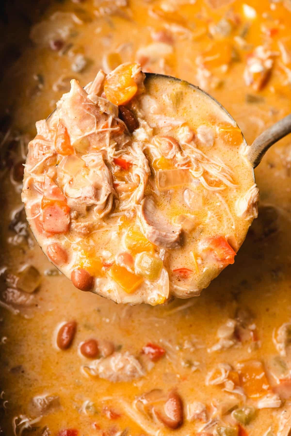 Big soup spoon full of slow cooker white chicken chili.