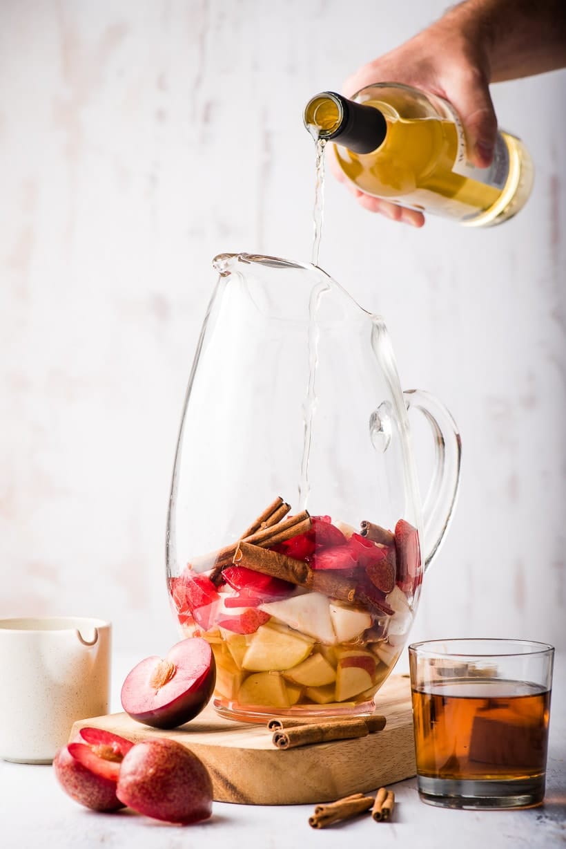 wine poured into pitcher of fall sangria