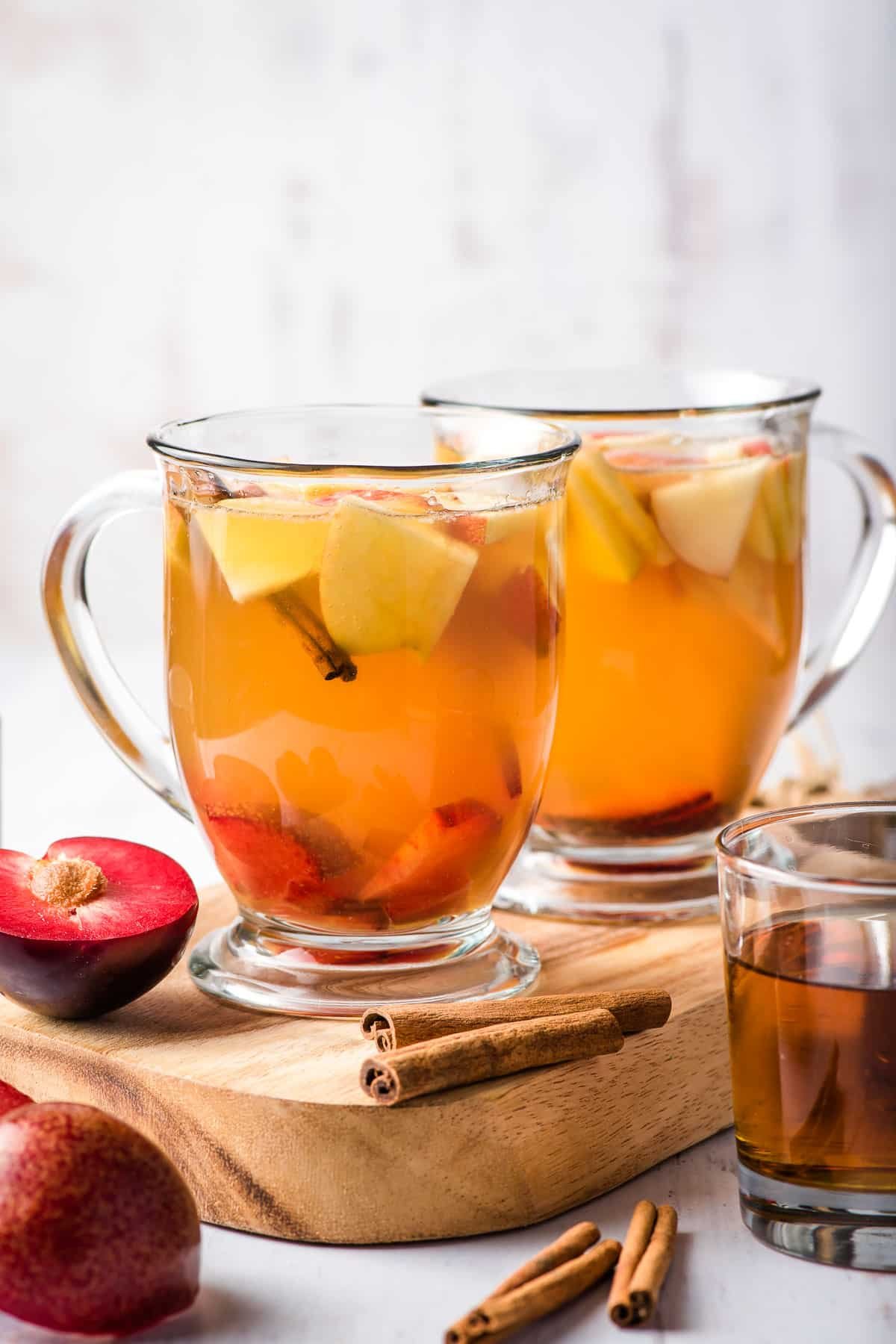 Autumn Sangria picture Two glasses of apple cider sangria on a cutting board.