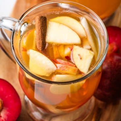 Fall sangria with apples and pears in a glass mug.