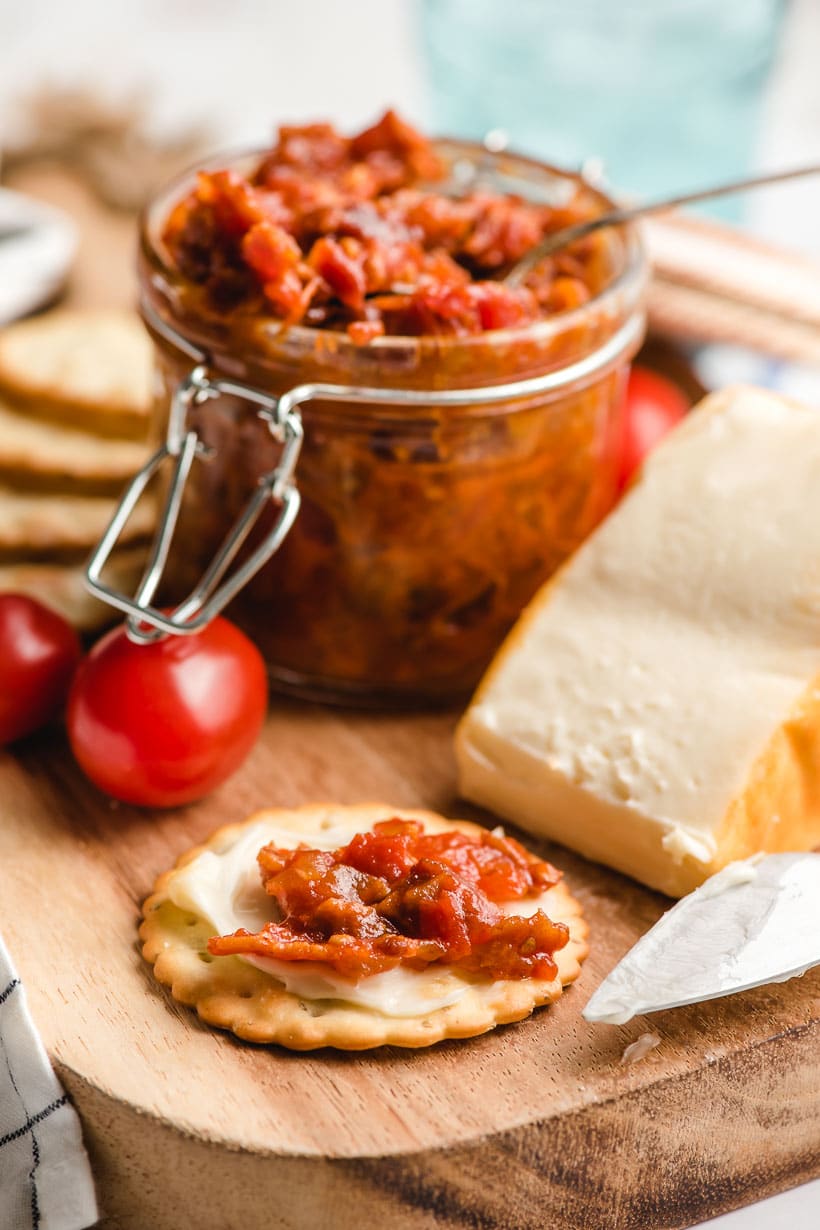 Tomato jam spread on a cracker with cheese.