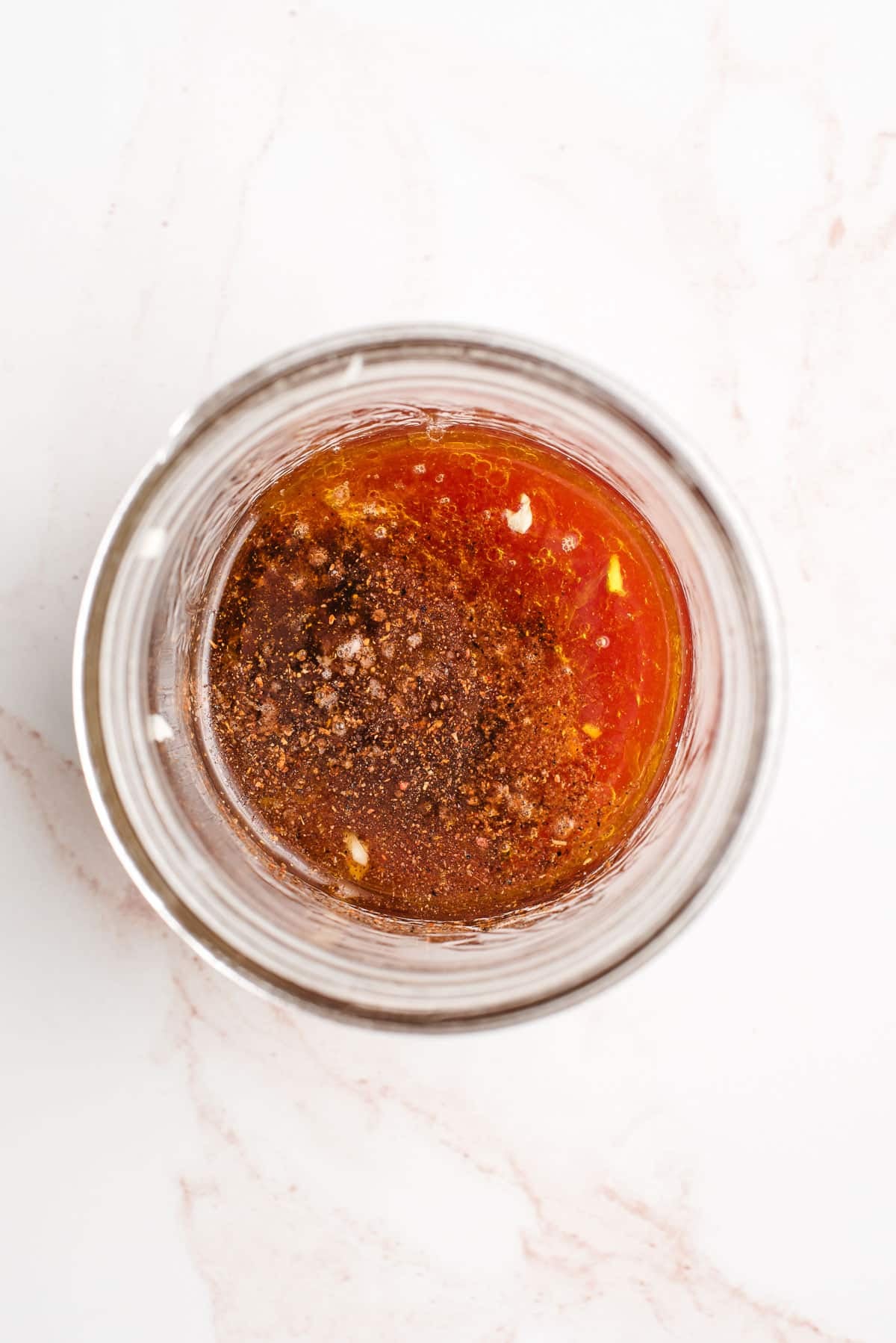 Red wine vinegar, lemon, lime, chili powder, and salt in a glass bowl.