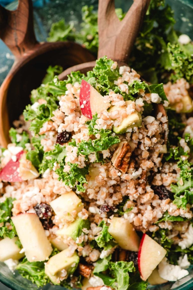 Wooden spoon scooping bulgur salad out of a bowl.