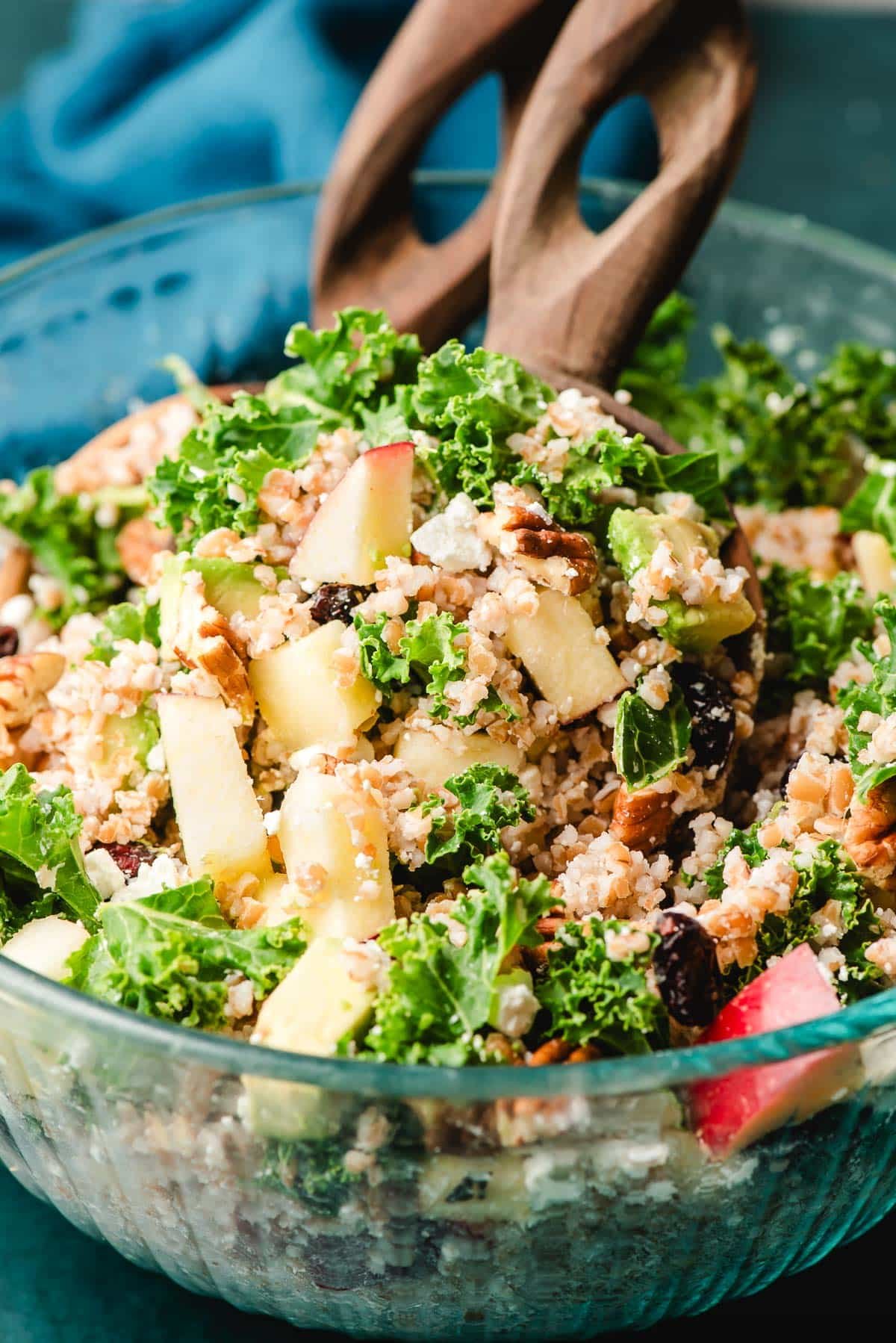 Big glass bowl of bulgur salad with apples and pecans.