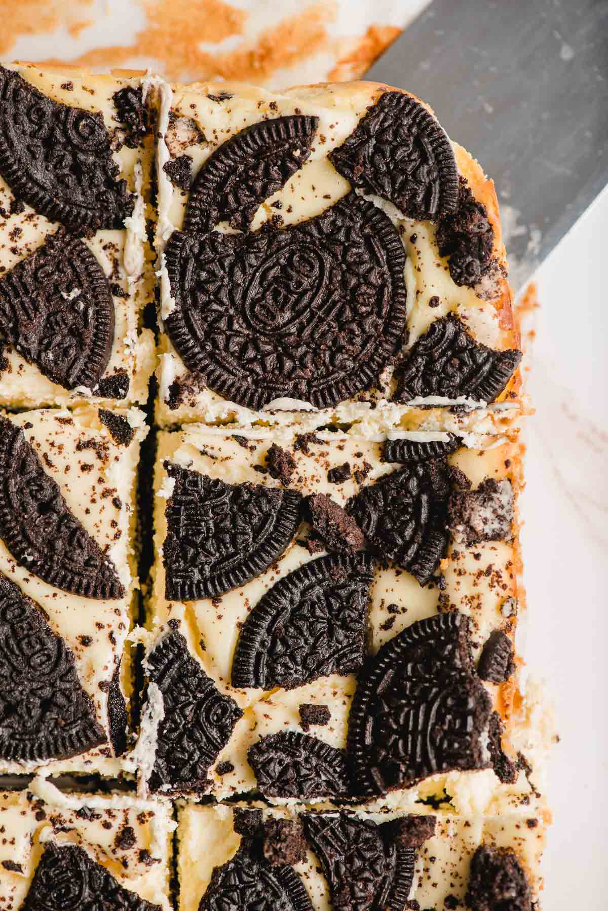 Spatula scooping out a slice of Oreo cheesecake.