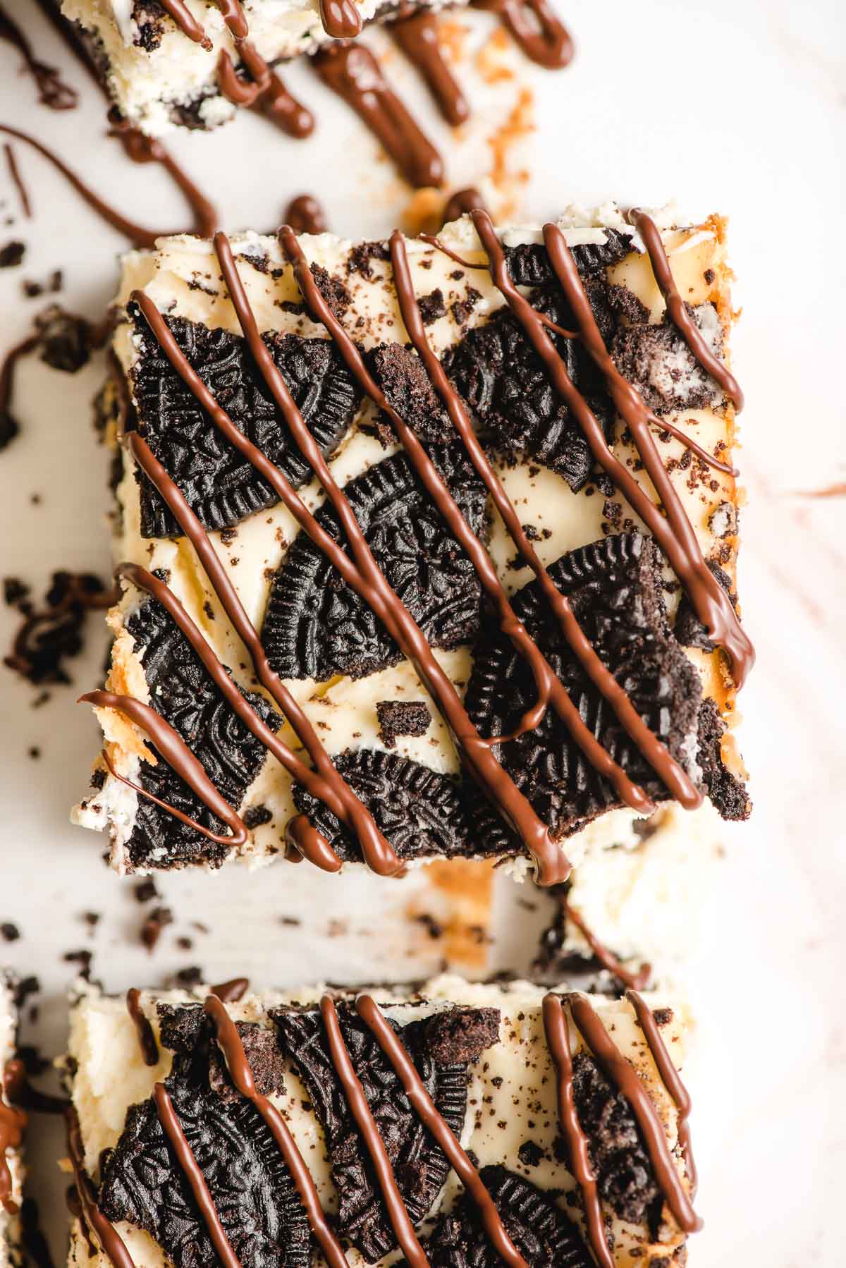 Slice or Oreo Cheesecake with chocolate drizzled on top.
