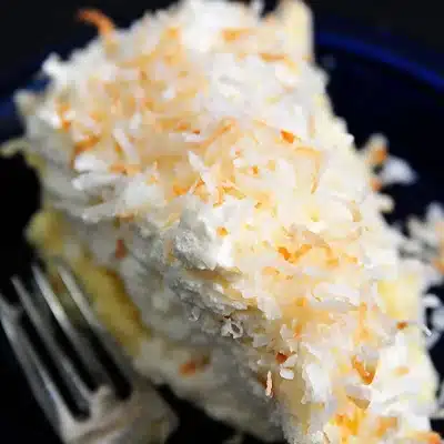 coconut cream pie next to a fork on a black surface