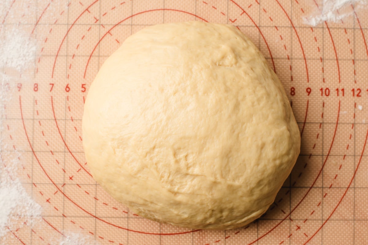 Paczki dough on a floured baking mat.