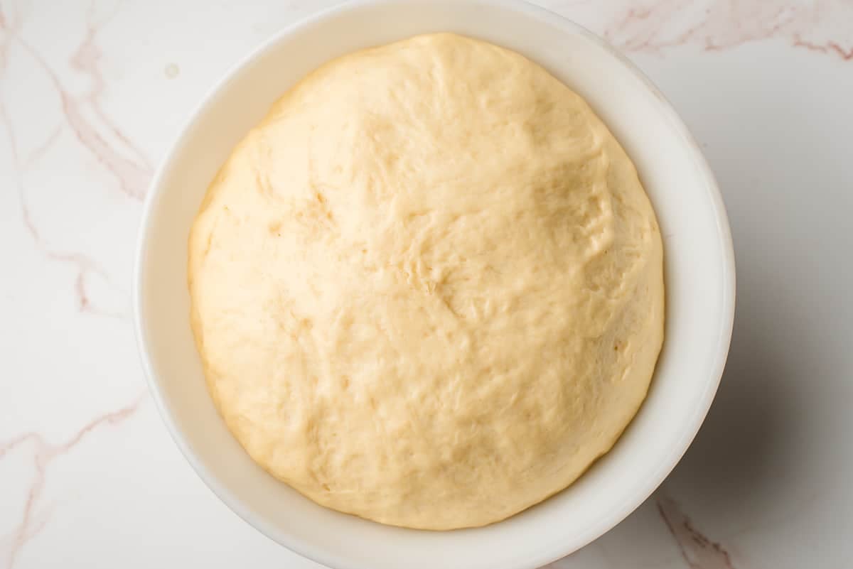 Yeast risen paczki dough in a mixing bowl.