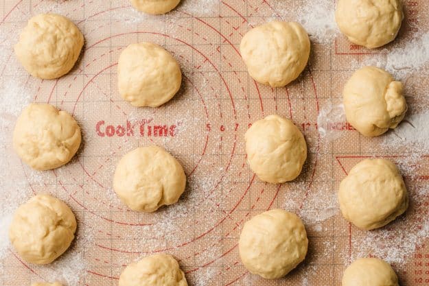 Paczki dough risen on a baking mat.