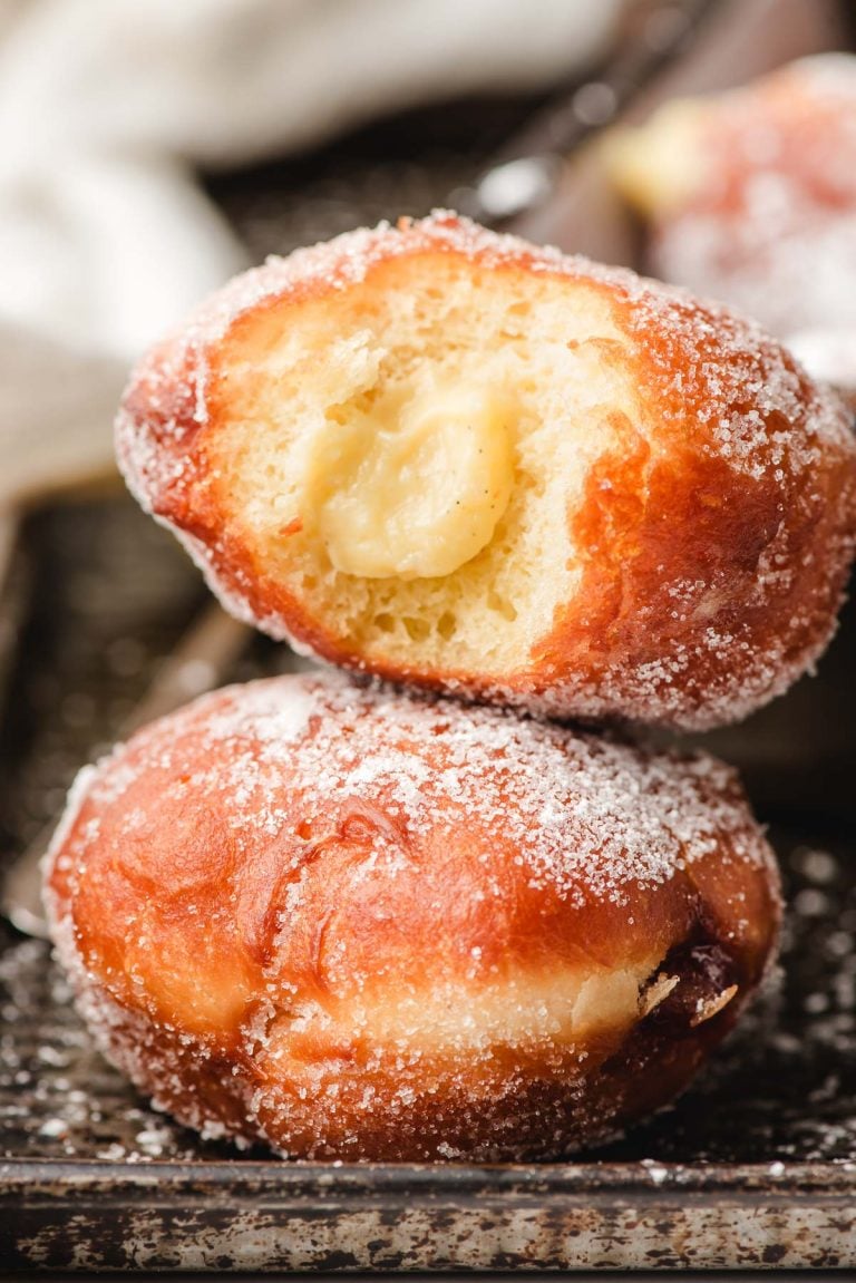 Custard filled paczki with a bite taken out of it.