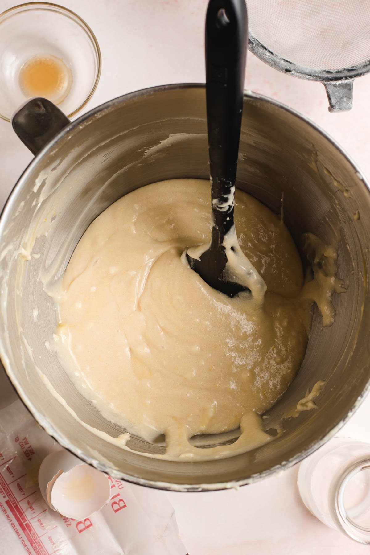 Buttery lemon cake batter in the bowl of an electric mixer.