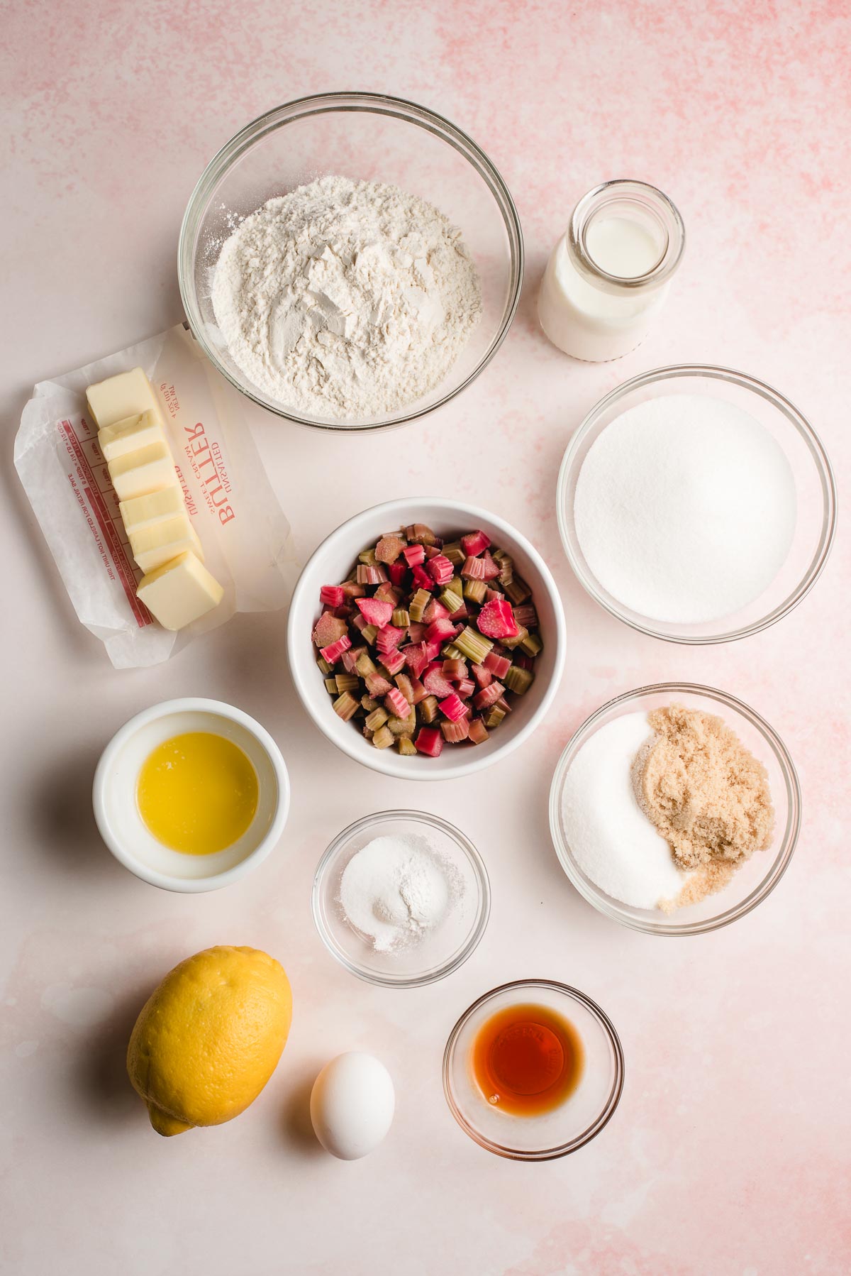 Ingredients for rhubarb cake shown on a pink background.
