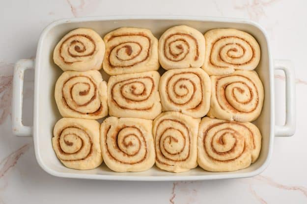 Unbaked orange cinnamon rolls puffed up and ready to go in the oven.