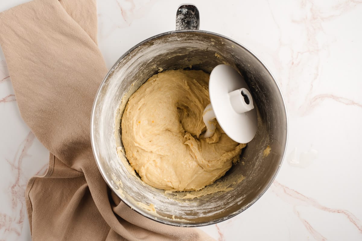 Orange roll dough in an electric mixing bowl with the dough hook.