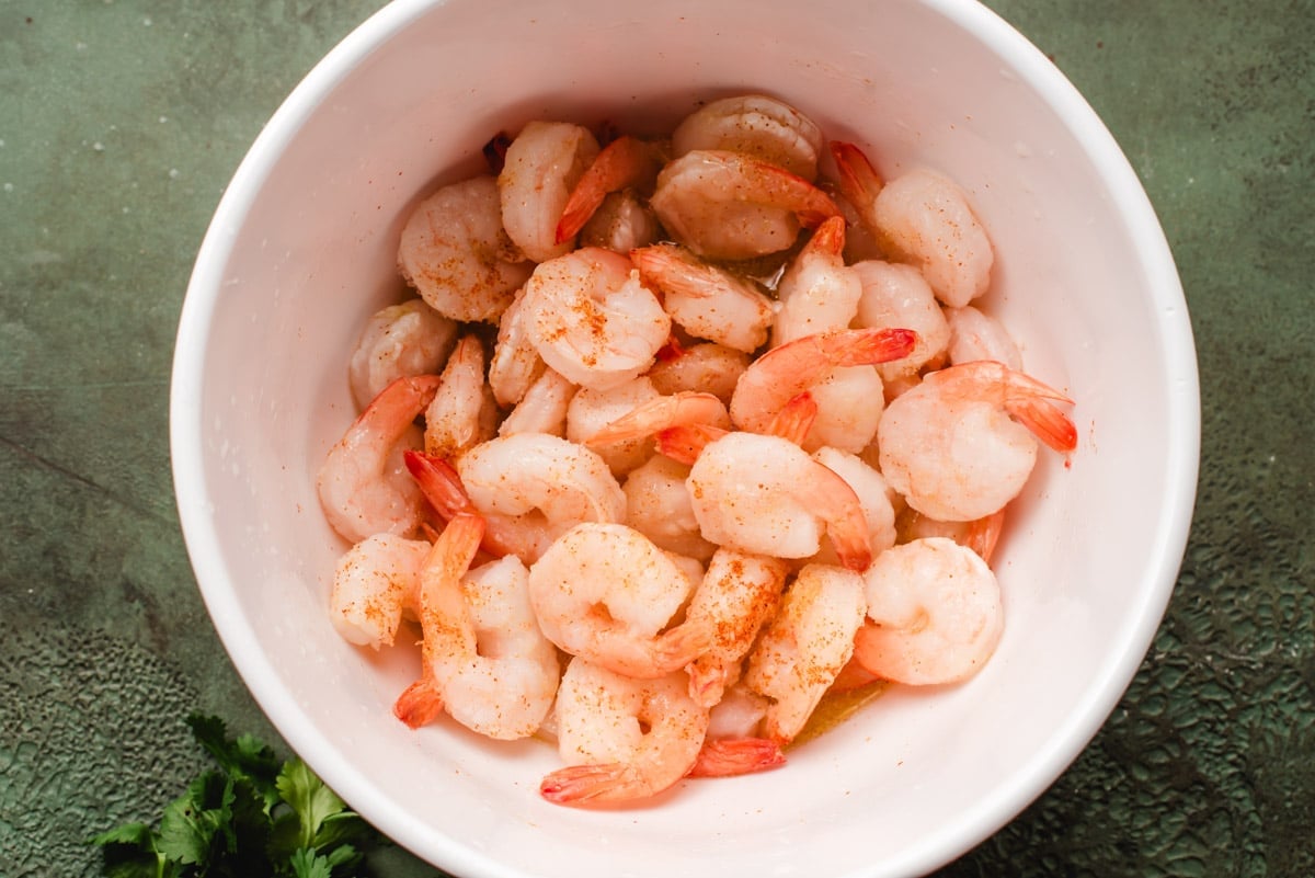 Shrimp in a bowl marinated with lime juice, tequila, and seasonings.