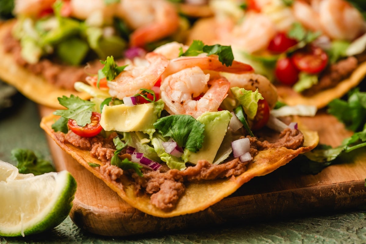 Shrimp tostadas on a cutting board.